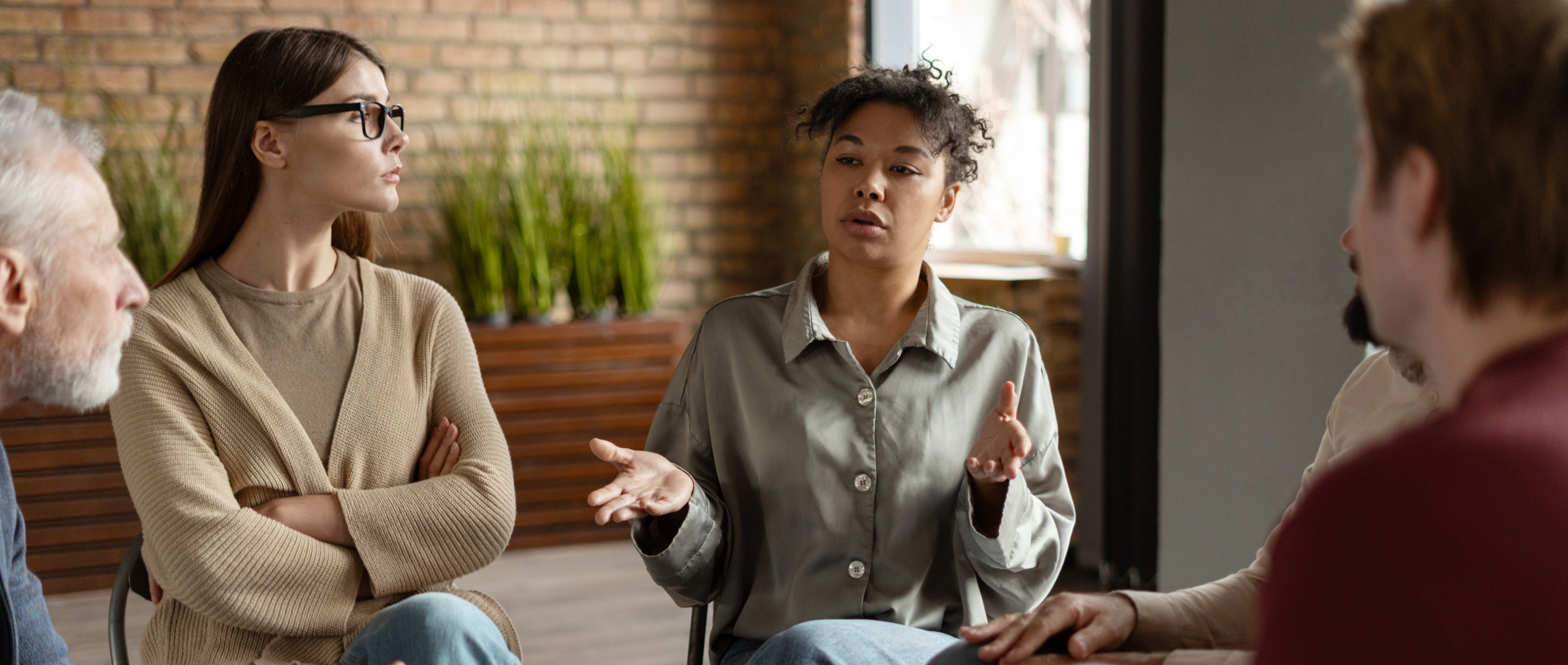 A woman sitting in a group and talking for the topic best inpatient rehab california.
